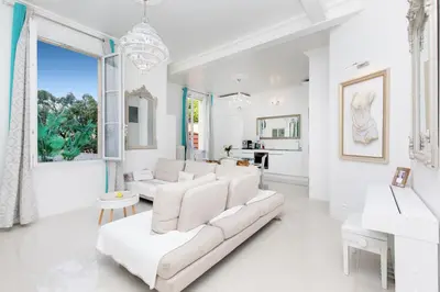 a living room with white furniture and a large window at Palais Beaulieu Magnifique 3p 2 chambres in Cannes