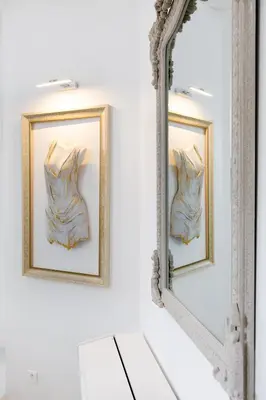 a mirror with two pictures of a dress on a wall at Palais Beaulieu Magnifique 3p 2 chambres in Cannes
