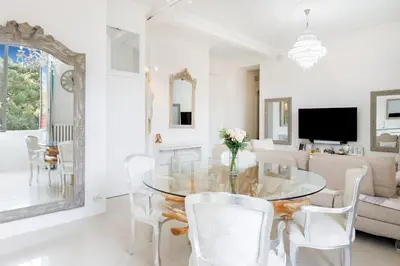 a dining room with a glass table and white chairs at Palais Beaulieu Magnifique 3p 2 chambres in Cannes