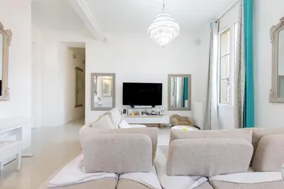 a living room with white furniture and a flat screen tv at Palais Beaulieu Magnifique 3p 2 chambres in Cannes