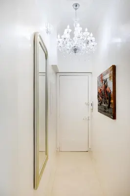 a hallway with a mirror and a chandelier at Palais Beaulieu Magnifique 3p 2 chambres in Cannes
