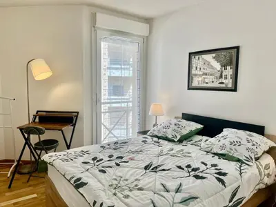 a bedroom with a bed and a desk and a window at Le Lys d'Or in Cannes