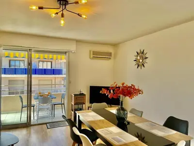 a living room with a table and a dining room at Le Lys d'Or in Cannes
