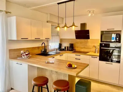 a kitchen with white cabinets and a wooden counter top at Le Lys d'Or in Cannes