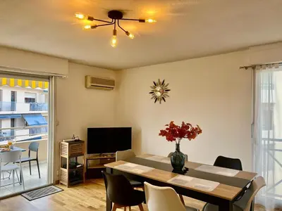a living room with a table and a ceiling fan at Le Lys d'Or in Cannes