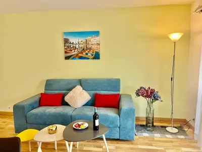 a living room with a blue couch and red pillows at Le Lys d'Or in Cannes