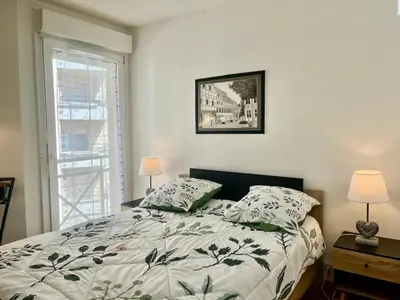 a bedroom with a bed with two pillows and a window at Le Lys d'Or in Cannes