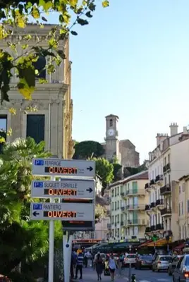 a street sign on a busy city street with buildings at Cannes - Centre- Film Festival in Cannes