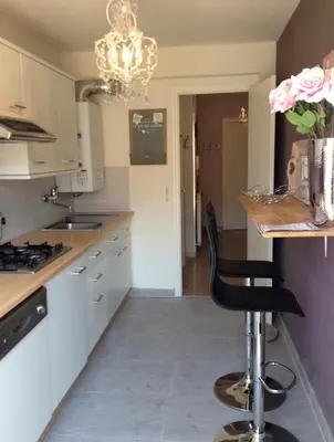 a kitchen with white cabinets and a black chair at Work or vacation - lovely apartment - central in Cannes
