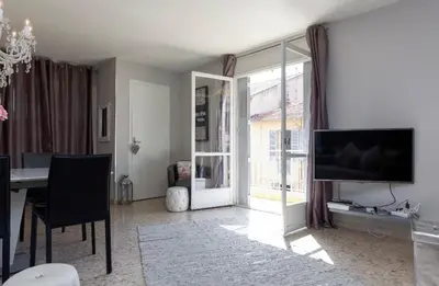 a living room with a dining table and a television at Work or vacation - lovely apartment - central in Cannes