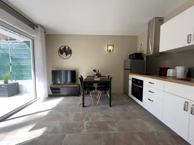 a kitchen with a table with a chair in it at COSY CASTILLE - Proche de la CROISETTE in Cannes