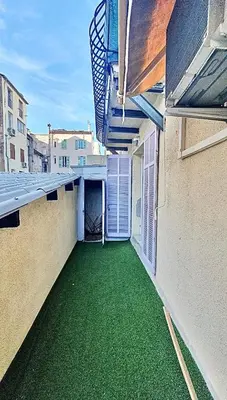 a balcony with green grass on the side of a building at Cannes 1-Bedroom Apartment - 15M in Cannes