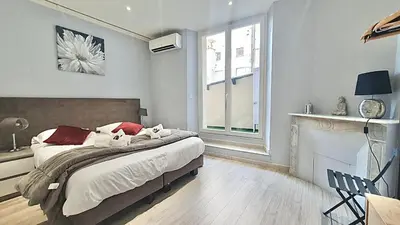 a bedroom with a large bed and a fireplace at Cannes 1-Bedroom Apartment - 15M in Cannes