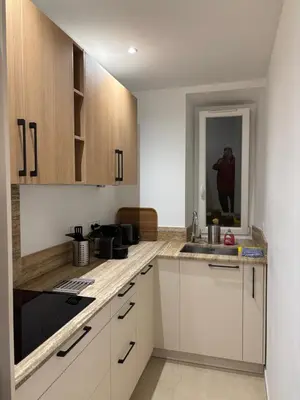a kitchen with white cabinets and a person in a mirror at STA4 Le Suquet, Proche Mer et Palais des Congrès in Cannes
