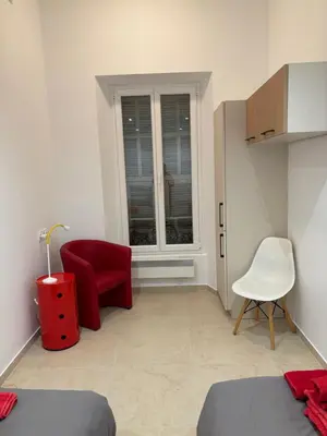 a bedroom with a red chair and a window at STA4 Le Suquet, Proche Mer et Palais des Congrès in Cannes