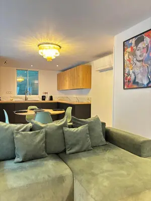 a living room with a couch and a kitchen at CANNES Maison Design 