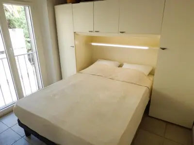 a small bed in a room with a window at Villa Divona - central gem with sunset balcony & pool in Cannes