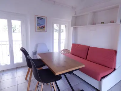 a living room with a red couch and a wooden table at Villa Divona - central gem with sunset balcony & pool in Cannes