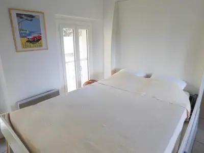 a white bed in a room with a window at Villa Divona - central gem with sunset balcony & pool in Cannes