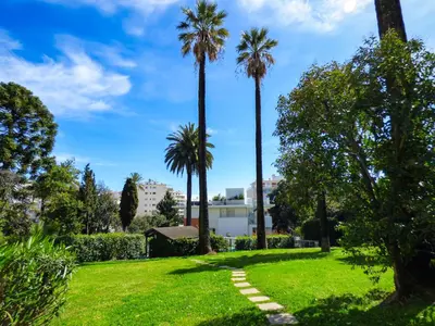 a park with palm trees and a path at Villa Divona - central gem with sunset balcony & pool in Cannes