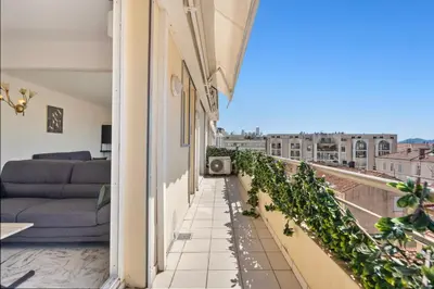 a balcony with a view of a living room at REF 1996 Cannes Croisette - Sea view apartment for rent in Cannes