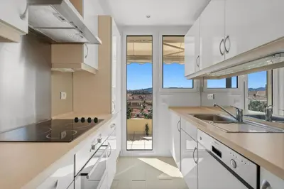 a kitchen with white cabinets and a large window at REF 1996 Cannes Croisette - Sea view apartment for rent in Cannes