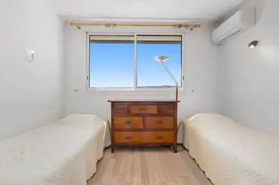 a bedroom with two beds and a dresser and a window at REF 1996 Cannes Croisette - Sea view apartment for rent in Cannes
