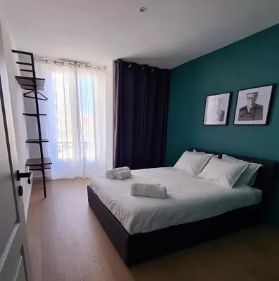 a bedroom with a large bed with a blue wall at 2 Bedrooms 5 min walk to Croisette in Cannes