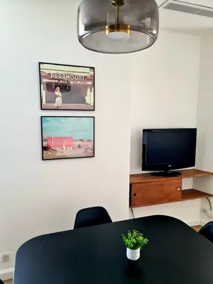 a dining room with a table and a tv at 2 Bedrooms 5 min walk to Croisette in Cannes