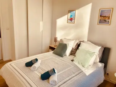 a bedroom with a bed with two slippers on it at Elégant T3 Cannes centre, 10 mn à pieds Palais, Croisette in Cannes