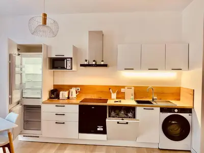 a kitchen with white cabinets and a washer and dryer at Elégant T3 Cannes centre, 10 mn à pieds Palais, Croisette in Cannes