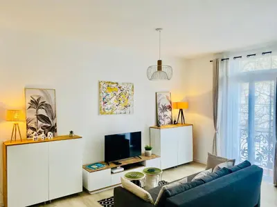 a living room with a blue couch and a tv at Elégant T3 Cannes centre, 10 mn à pieds Palais, Croisette in Cannes