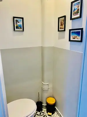 a bathroom with a toilet and pictures on the wall at Elégant T3 Cannes centre, 10 mn à pieds Palais, Croisette in Cannes