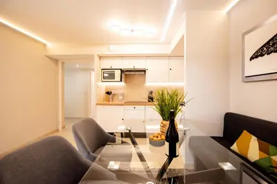 a living room with a glass table and a kitchen at Sunny Palazzio T3 Old Port, Beaches, Congress in Cannes
