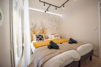 a bedroom with a large white bed with colorful pillows at Sunny Palazzio T3 Old Port, Beaches, Congress in Cannes