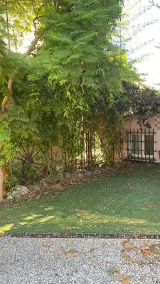 a building with a fence next to a tree at une pépite ZEN et COSY, parking jardin, idéal pour se ressourcer au calme in Le Cannet
