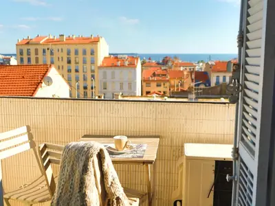 a balcony with a table and a cup of coffee at Les Bananiers centre ville Cannes in Cannes