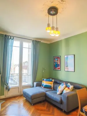 a living room with a couch and a large window at Les Bananiers centre ville Cannes in Cannes