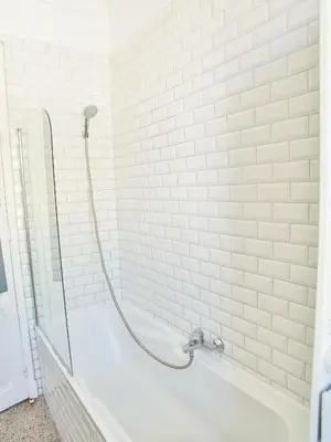 a white bath tub with a shower head in a bathroom at Les Bananiers centre ville Cannes in Cannes