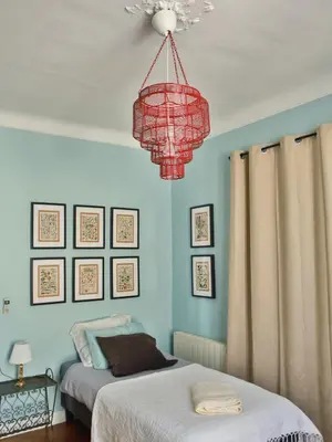 a bedroom with two beds and a red chandelier at Les Bananiers centre ville Cannes in Cannes