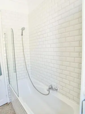 a white bath tub with a shower in a bathroom at Les Bananiers centre ville Cannes in Cannes