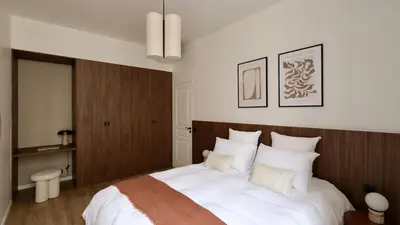 a bedroom with a large white bed with a wooden headboard at Somptueux avec grande terrasse in Cannes