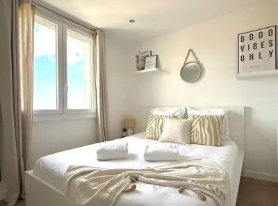 a bedroom with a white bed with pillows and a window at T3 Sea view walking distance of Palais, AC , Parking, Terrace in Cannes