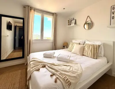 a bedroom with a large white bed with a large mirror at T3 Sea view walking distance of Palais, AC , Parking, Terrace in Cannes