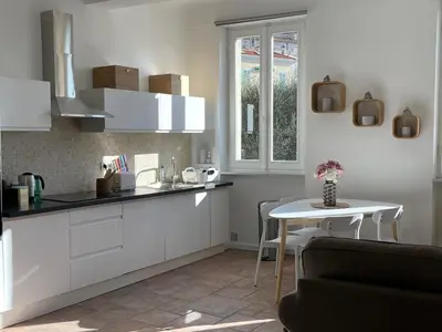 a kitchen with white cabinets and a table and a window at CANNES SUQUET spacieux studio in Cannes