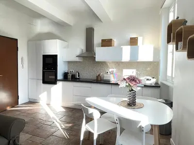 a white kitchen with a white table and chairs at CANNES SUQUET spacieux studio in Cannes