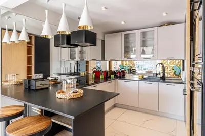 a kitchen with white cabinets and a black counter top at Modern apartment - 3BR- 6P - Croisette Plage in Cannes
