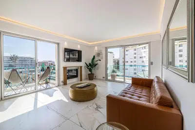 a living room with a couch and large windows at Modern apartment - 3BR- 6P - Croisette Plage in Cannes