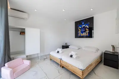 a bedroom with a bed and a pink chair at Modern apartment - 3BR- 6P - Croisette Plage in Cannes