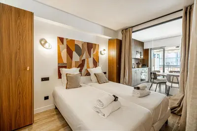 a hotel room with two beds and a balcony at Charming flat - 2BR-6P - Cannes in Cannes